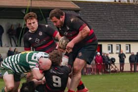 Ronan Hooper is tackled by a Greystones player, gets the offload away to Dan Cronin.