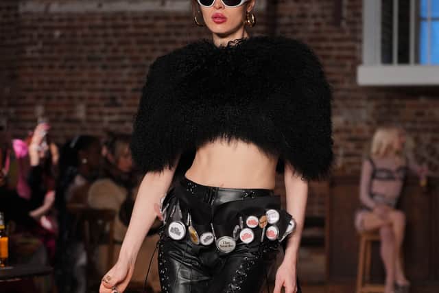 Two pool tables lined the runway and a bar installation anchored the end of the catwalk, as a mash-up of Pixies, Joy Division and Pulp blasted through the space. Models occasionally paused to chalk a cue or take a swig from a bottle before continuing down the runway, blurring the line between performance and presentation.