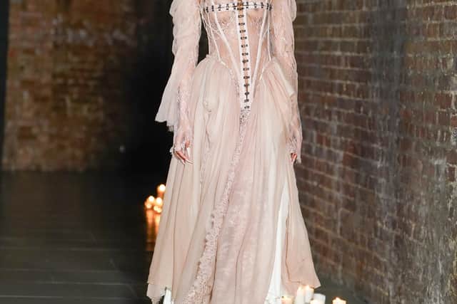 Romantic draping softened the severity. Silk and chiffon cascaded from tightly laced bodices, while Chantilly lace and tulle were layered to create depth and movement. In several looks, the corset acted as both centrepiece and anchor – pulling the waist inward before releasing into fluid skirts or trailing panels of sheer fabric.
