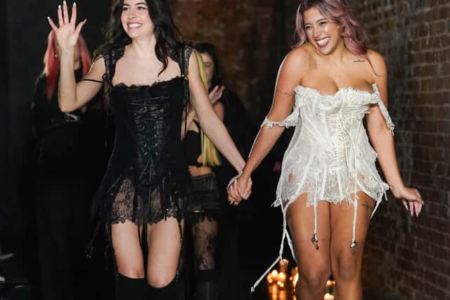 The show closed with Trombatore herself joining a model on the runway, both dressed in corseted mini silhouettes – one in black lace, the other in ivory – underscoring the collection’s core message of solidarity and female strength.
