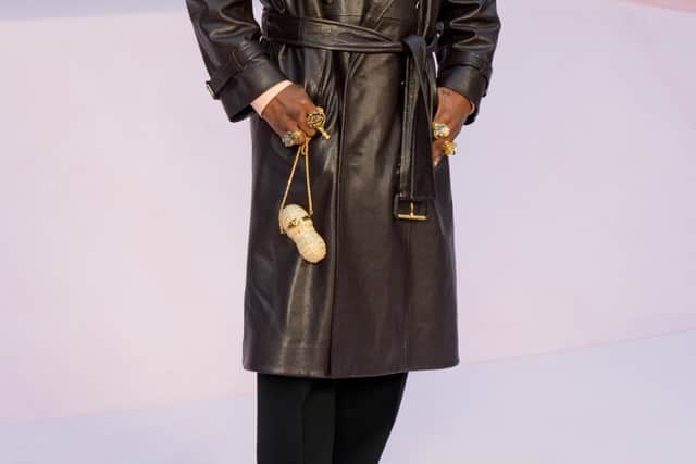 Rapper A$AP Rocky, whose long-term partner Rihanna attended the Dior haute couture show on Monday, kept it pared back in a brown leather trench and salmon shirt.