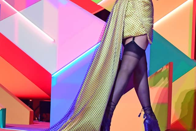 For her red carpet arrival, she wore a Clueless-esque golden-yellow, off-the-shoulder minidress with a corset-style bodice. She also paid homage to the late British singer Amy Winehouse with a retro brunette beehive.