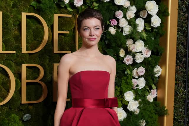 For the look, Stone let her hair do the talking, wearing a striking strapless red-hot Louis Vuitton gown, with a cinched waist belt adorned with an asymmetrical bow.