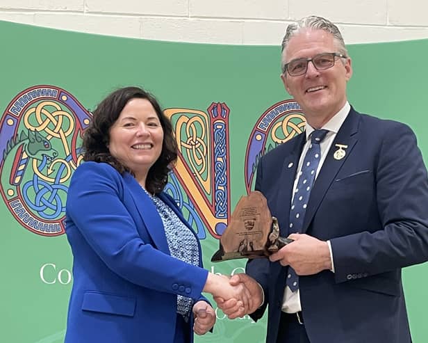 Principal Victoria Guinan presenting President of the GAA Jarlath Burns with a specially commissioned 4,600-year-old piece of local big yew.