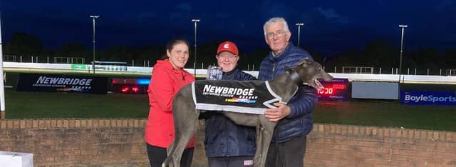 Newbridge racing manager Joyce Black making the presentation to. Geashill owners Thomas Garry and Liam Kirley after Glenlara Blue win the final of the This Runs Deep A3 stake on Friday