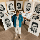 Shane Gillen pictured surrounded by his hand-drawn portraits. The artist spent part of his childhood in Tullamore