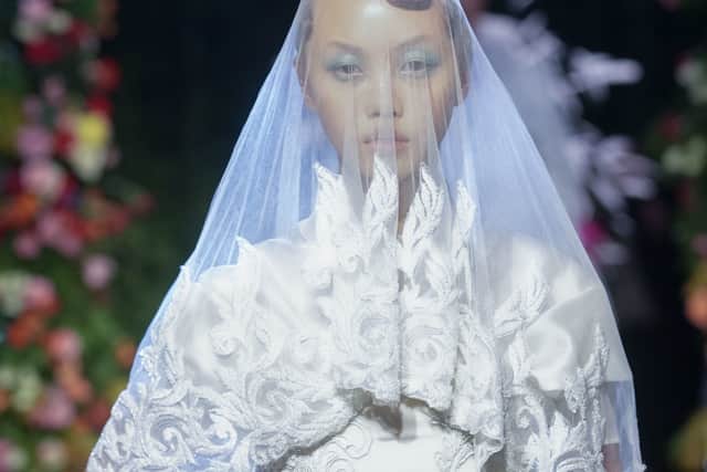 Quinn also explored bridalwear in the autumn/winter collection. This ranged from a model wearing a more classic white gown with a traditional veil, to a more experimental offering of a lace maxi dress, covered in feathers and with pink floral accents.