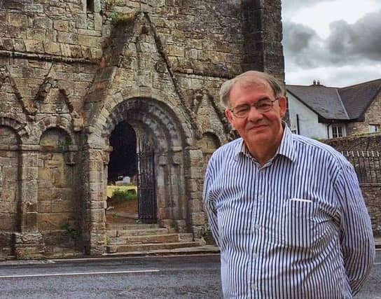 Adrian pictured at the west gable of St Cronan's 12th century romanesque church in Roscrea. Photo: D. Keegan
