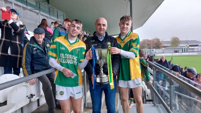 K-K joint captains and first cousins, Daniel Hand and Adam Screeney receive the MHC Cup from Offaly GAA secretarty, Colm Cummins.
