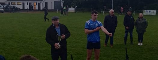 Morgan Tynan about to receive the cup from County Board vice chairman James Murphy