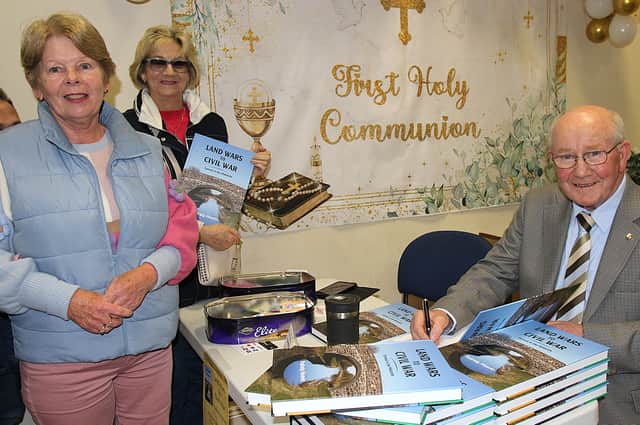Author Padraig Heavin pictured signing copies of his latest book for his first cousin Phyllis McIntyre and behind her is Bridget Sullivan, chairperson of Birr Historical Society