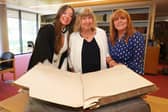 Hannah Clarke, her grandmother Margaret Moloney and mother Anne Clarke with the University of Galway student register, showing the signature of Hannah’s great-grandmother, Mary C. Whyte. 