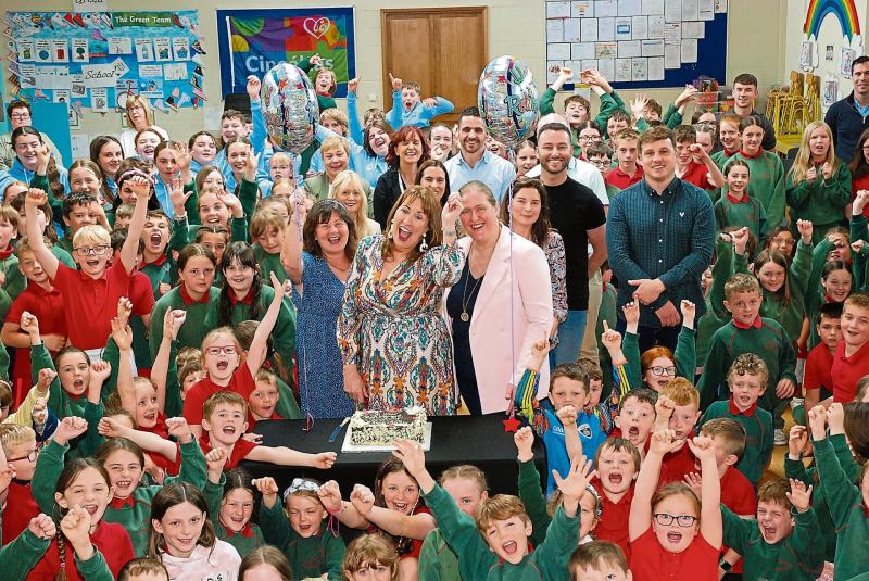 Cutting the cake! Teachers, pupils and staff pictured with Veronica on her last day. Photo: P.J. Wright.